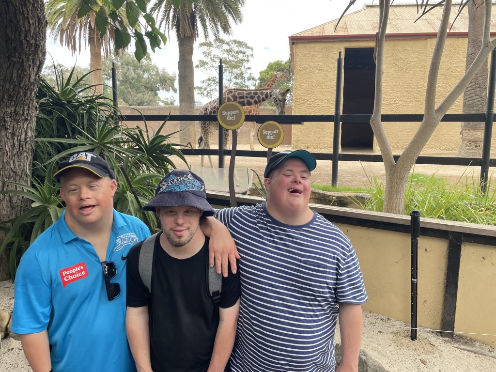 Orana clients Joel and Shane at the Adelaide Zoo - standing in front of the giraffe encolsure.